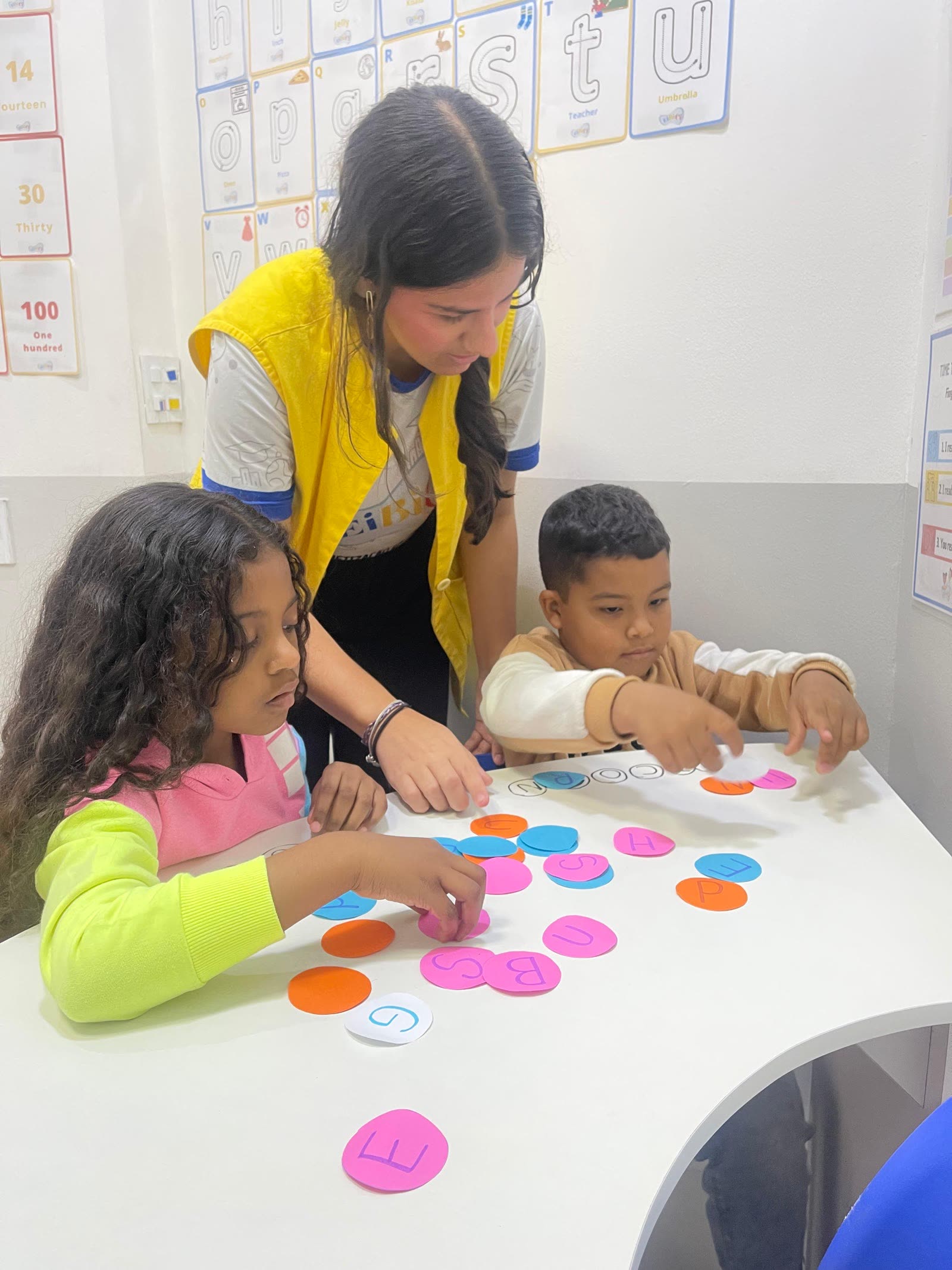 Crianças organizando fichas coloridas em atividade de sons em inglês