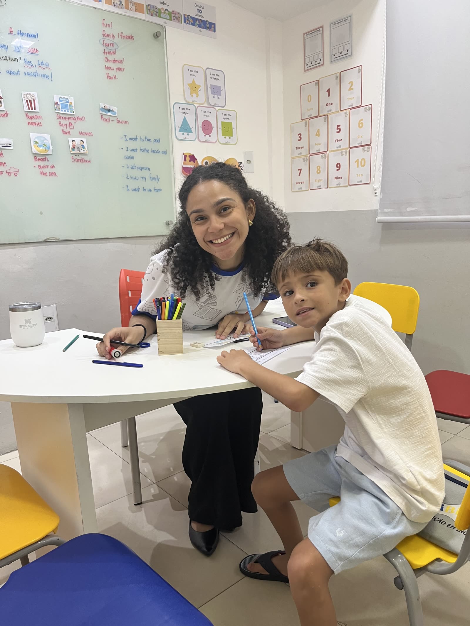 Professora acompanhando de perto uma criança durante a atividade